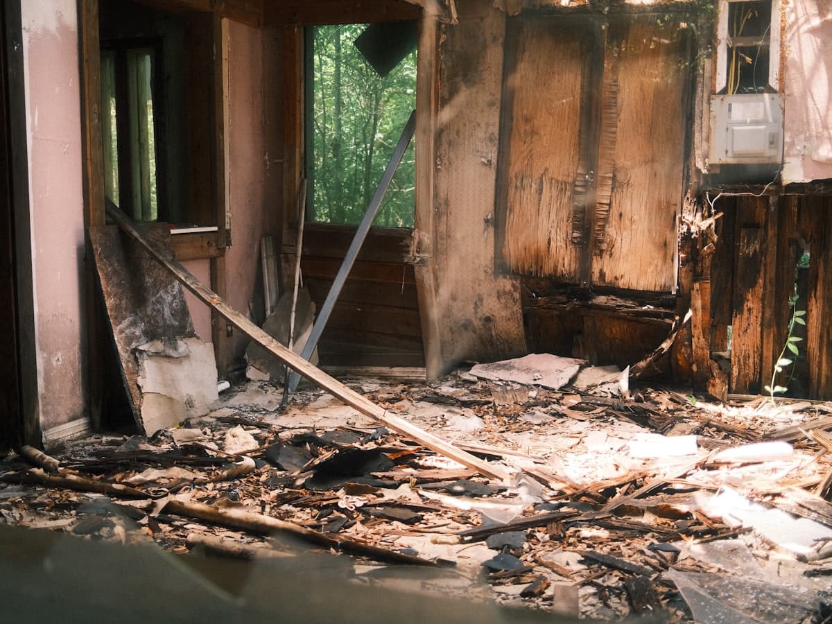 Fire-gutted room interior with charred walls and burnt debris across the floor